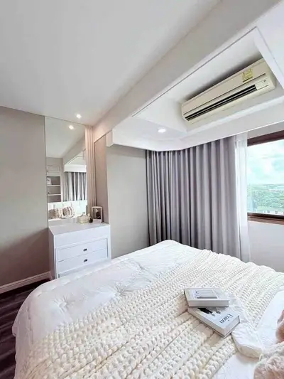 Cozy bedroom with modern decor, large window, and air conditioning unit, offering a serene and comfortable living space.