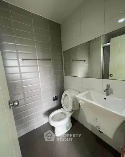 Modern bathroom with sleek fixtures and large mirror in a contemporary home.