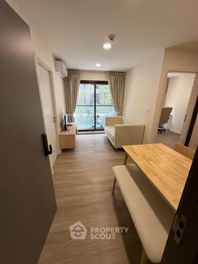 Modern living room with wooden flooring and large window view