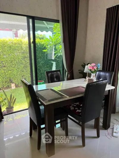 Elegant dining area with garden view, featuring modern table and chairs, perfect for family gatherings.