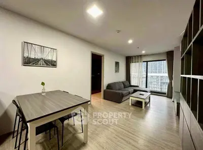 Spacious modern living room with stylish decor and large windows offering city views.