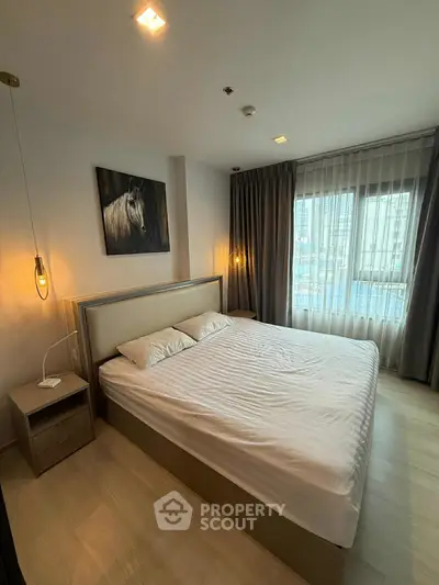 Modern bedroom with stylish decor and large window for natural light.