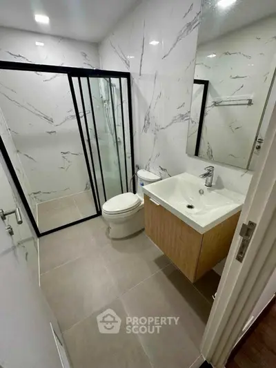 Modern bathroom with sleek design, featuring a glass shower enclosure and stylish vanity.