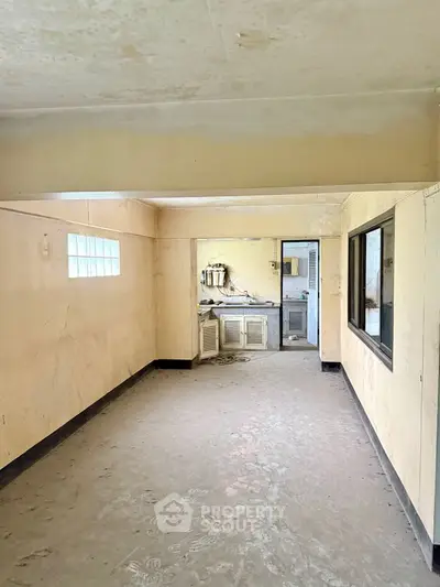 Spacious interior with potential for renovation, featuring a basic kitchen area.