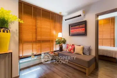 Stylish living room with modern decor and large windows with wooden blinds.