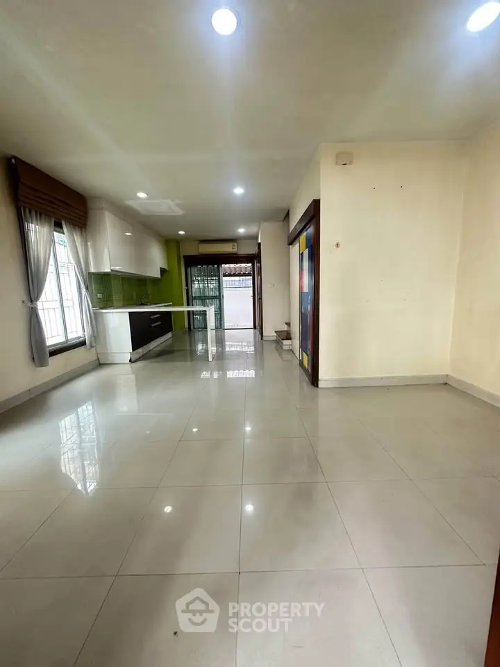 Spacious open-plan living area with modern kitchen and large windows for natural light.