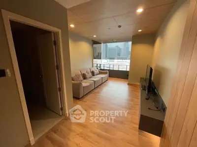 Modern living room with city view, wooden flooring, and cozy seating area.