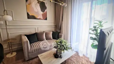 Elegant living room with plush sofa, modern decor, and large window for natural light.