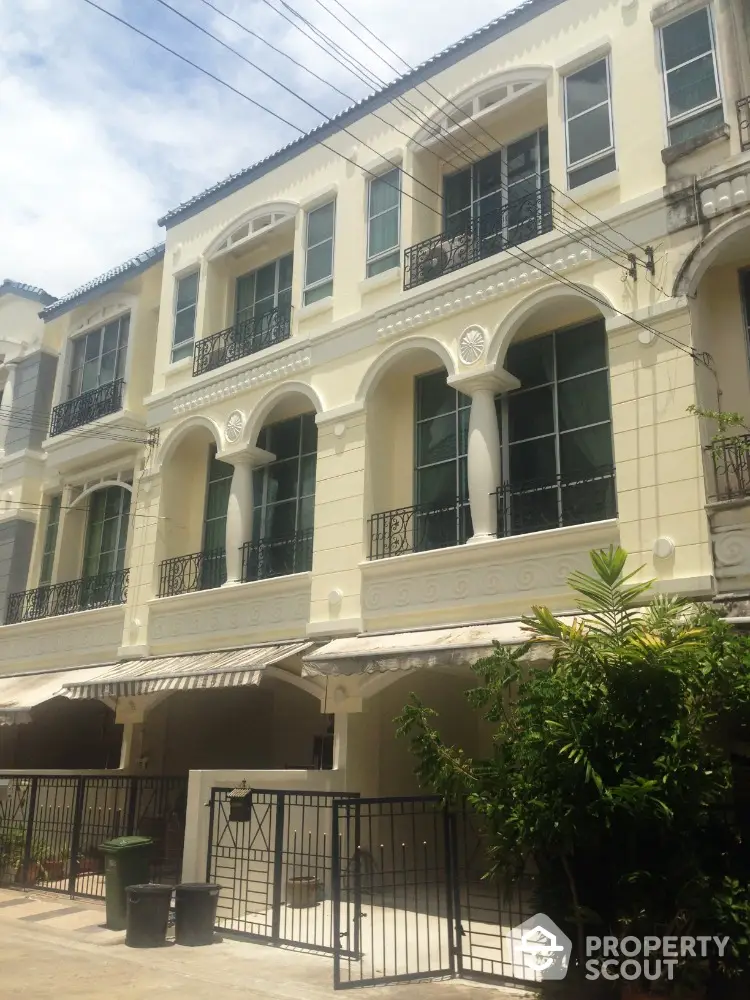 Elegant three-story townhouse with classic architecture and gated entrance