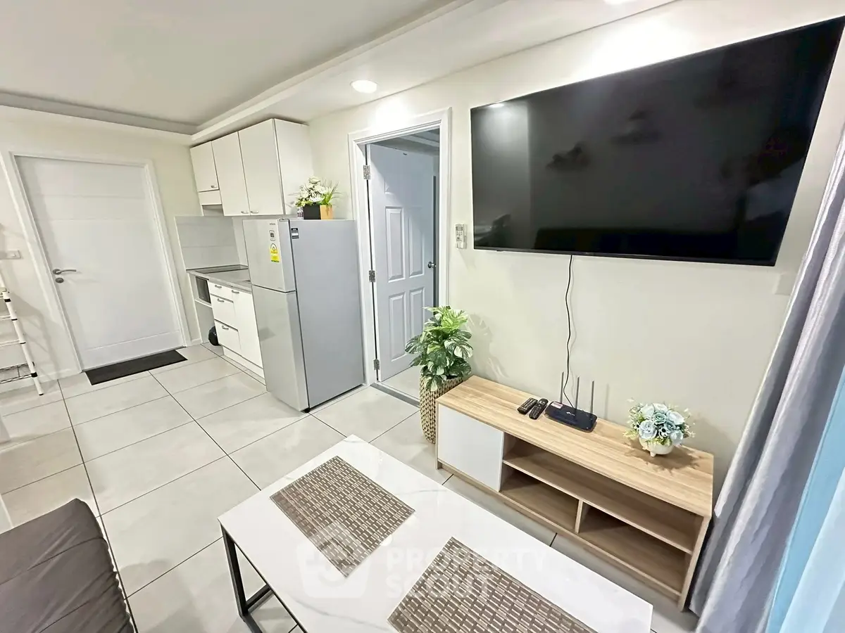 Modern living room with sleek kitchen and large TV, perfect for urban living.