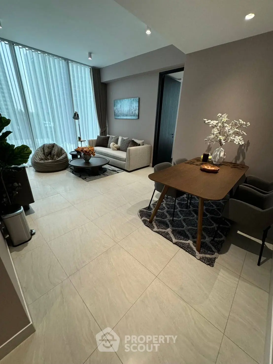 Modern living room with elegant decor and natural light, featuring cozy seating and stylish dining area.