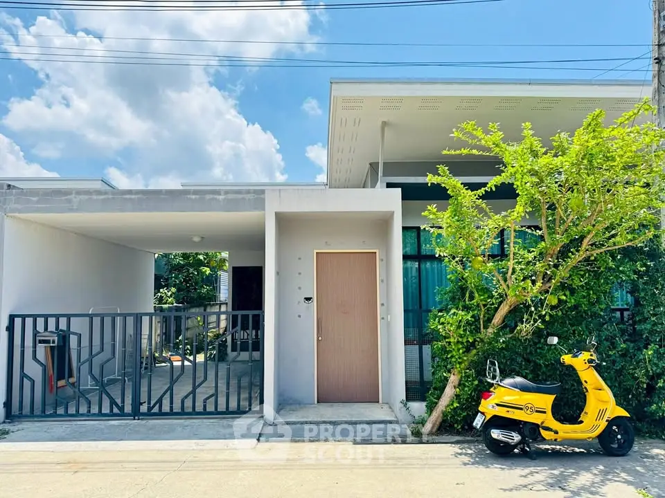 Modern single-story house with a minimalist facade and vibrant yellow scooter parked outside.