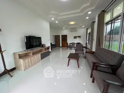 Spacious modern living room with sleek furniture and large windows offering natural light.