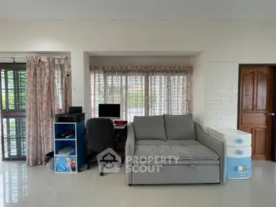 Cozy living room with modern sofa and workspace by large windows