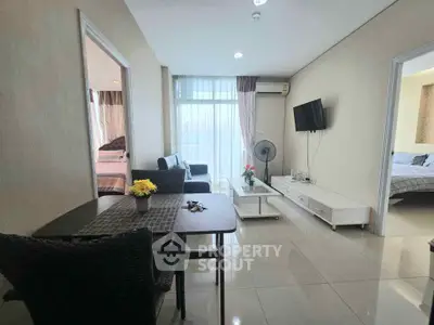 Modern living room with elegant decor and natural light, featuring a cozy seating area and stylish dining space.