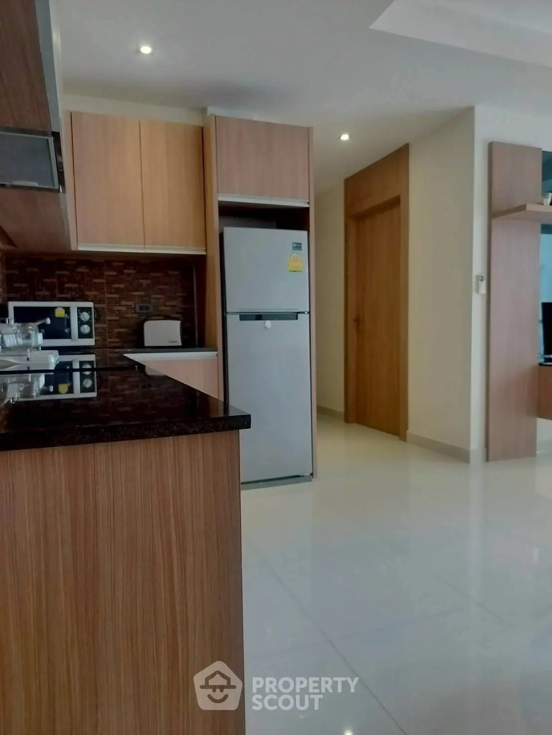 Modern kitchen with sleek wooden cabinets and stainless steel appliances.