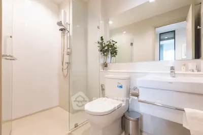 Modern bathroom with glass shower and sleek fixtures in a bright, minimalist design.