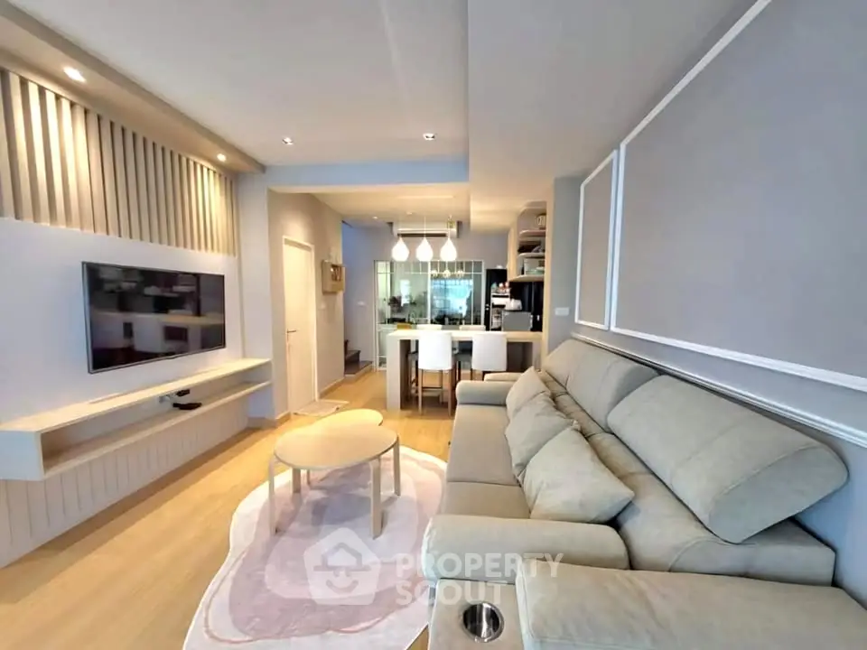 Modern living room with cozy beige sofa and stylish open kitchen layout.