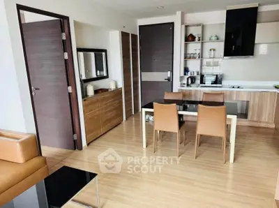 Modern open-layout kitchen and dining area with sleek wooden finishes and contemporary furniture.