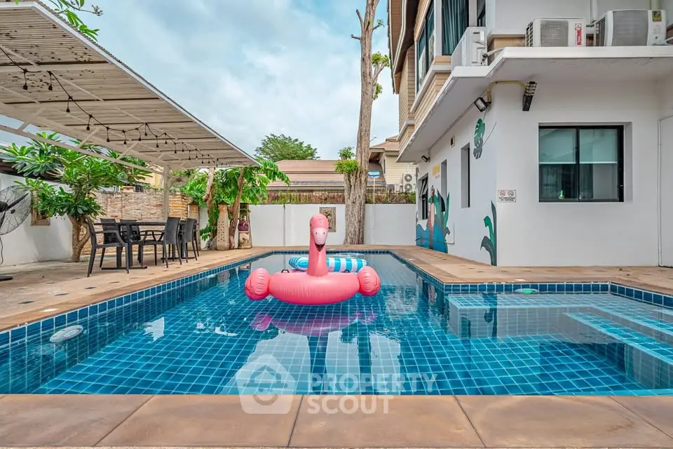 Charming residential pool with inflatable flamingo, perfect for relaxation and entertainment in a modern home setting.
