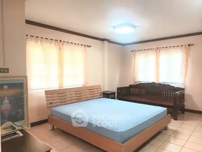 Spacious bedroom with natural light and elegant wooden furniture