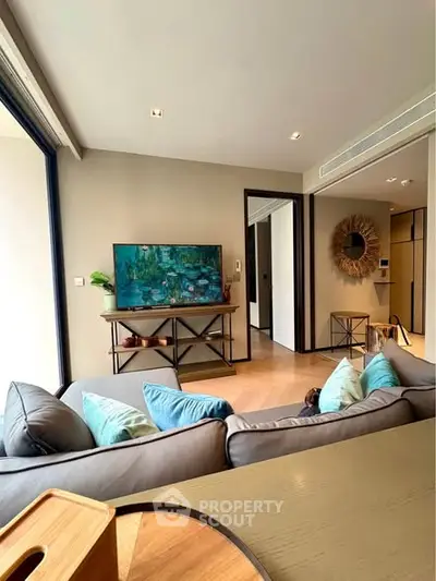 Modern living room with stylish decor and large windows offering natural light.