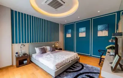 Modern bedroom with stylish blue accent wall and cozy decor