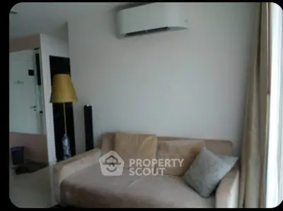 Cozy living room with beige sofa and modern air conditioning unit, perfect for relaxation.
