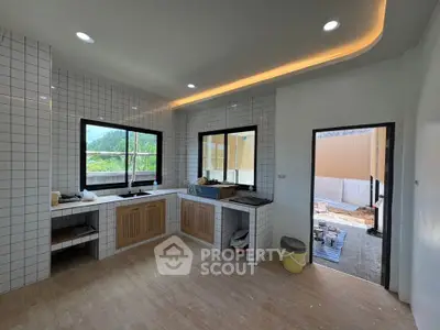 Modern kitchen with sleek design, featuring large windows and tiled walls, perfect for culinary enthusiasts.