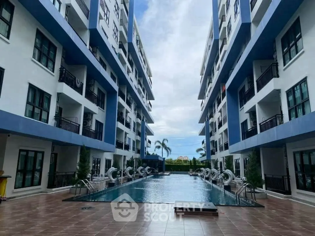 Modern apartment complex with a central swimming pool and sleek architecture.