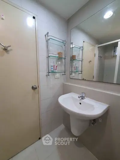 Modern bathroom with wall-mounted sink and glass shelves