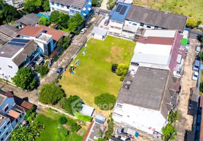 Aerial view of residential buildings surrounding a spacious green courtyard with playground equipment.