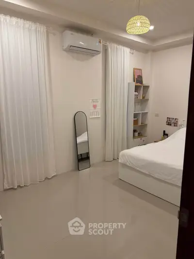 Cozy bedroom with modern decor, featuring a sleek mirror and air conditioning for ultimate comfort.