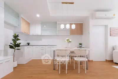 Modern kitchen with open layout and stylish dining area, featuring sleek cabinetry and contemporary lighting.