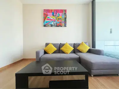 Modern living room with stylish gray sofa and vibrant artwork, perfect for urban living.
