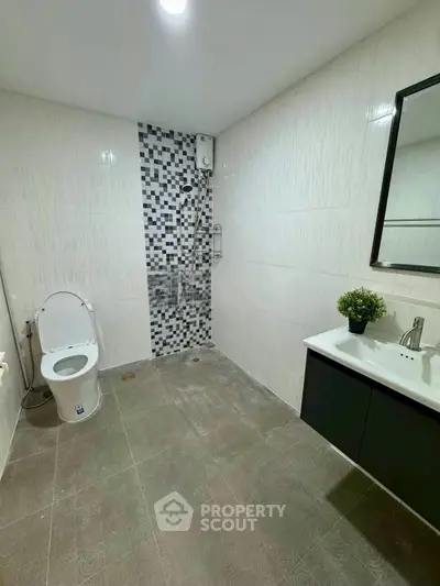 Modern bathroom with sleek design and stylish tile accents, featuring a shower and vanity.