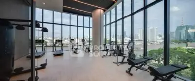 Luxurious gym with panoramic city views and modern fitness equipment in high-rise building.