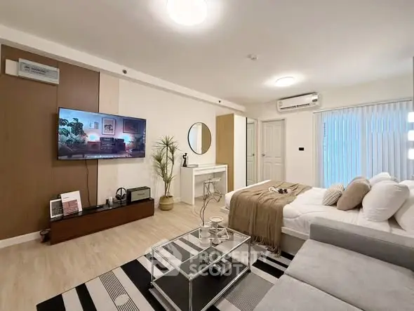 Modern living room with stylish decor, cozy seating, and a mounted TV, perfect for relaxation and entertainment.