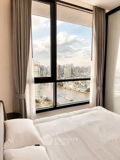 Luxurious bedroom with stunning city skyline view through large windows, featuring elegant curtains and plush bedding.