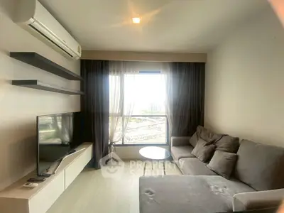 Cozy living room with modern sofa, TV, and large window view.