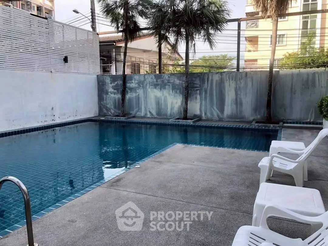 Inviting outdoor pool area with modern design and lush greenery.