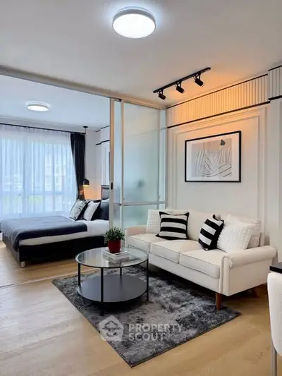 Modern open-plan living room with stylish decor and cozy bedroom view