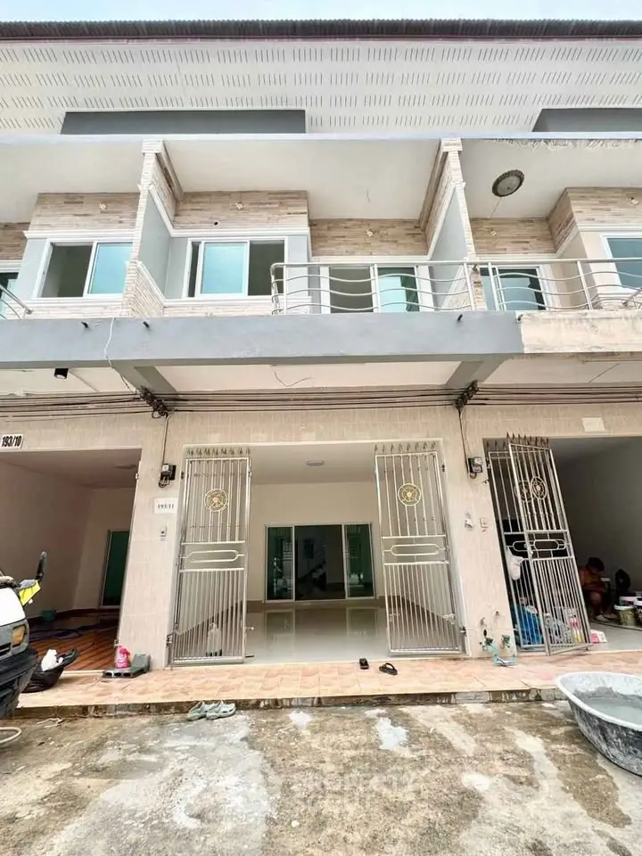Modern townhouse exterior with gated entrance and balcony, ideal for urban living.
