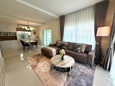Spacious modern living room with elegant decor and dining area, featuring large windows and stylish furnishings.