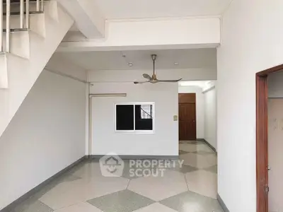 Spacious interior with modern flooring and ceiling fan, ideal for versatile living space.