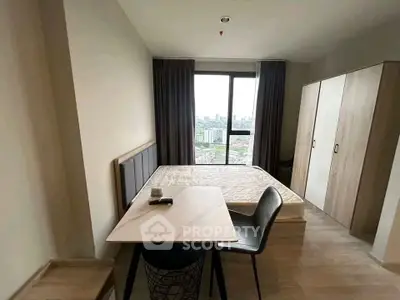Modern bedroom with city view, featuring a cozy bed, stylish table, and ample wardrobe space.