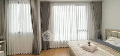 Bright and airy bedroom with elegant curtains and cozy bedding