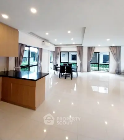 Spacious modern living room with large windows and elegant dining area