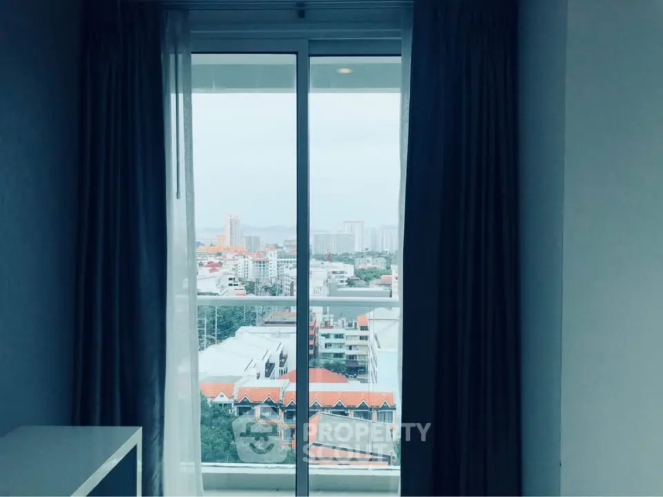 Stunning cityscape view from a high-rise apartment window with elegant curtains.