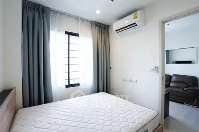 Modern bedroom with air conditioning and stylish curtains in a cozy apartment.